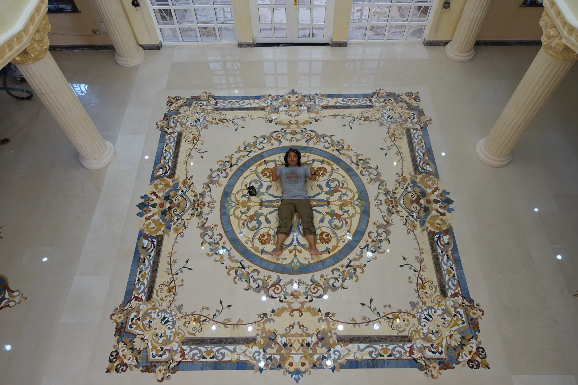 Luxury marble flooring in Tanzania, featuring a detailed marble inlay design. Custom marble floor medallion with pietre dure elements.