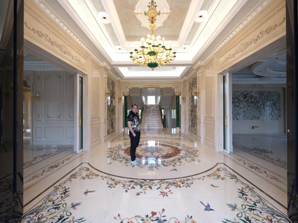 Polished marble floor with floral inlay borders and a central waterjet medallion in a luxury hall.