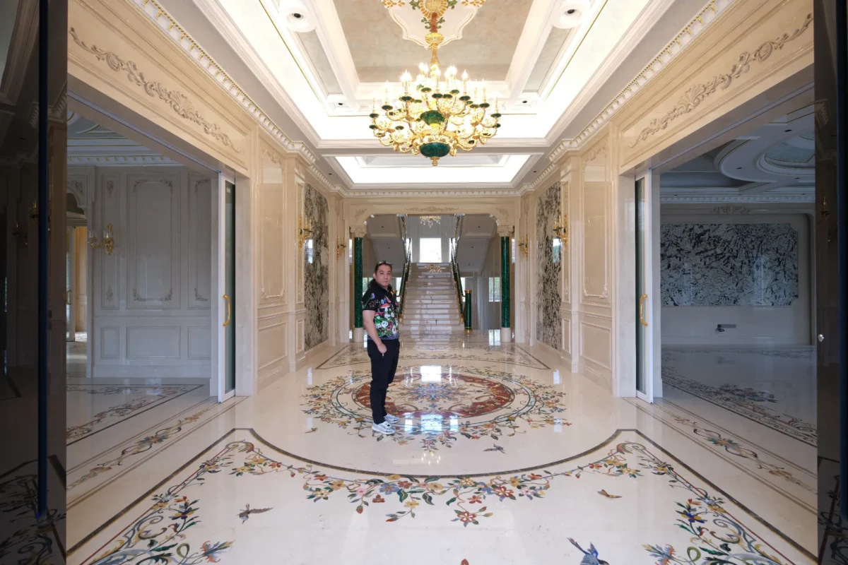 Polished marble floor with floral inlay borders and a central waterjet medallion in a luxury hall.