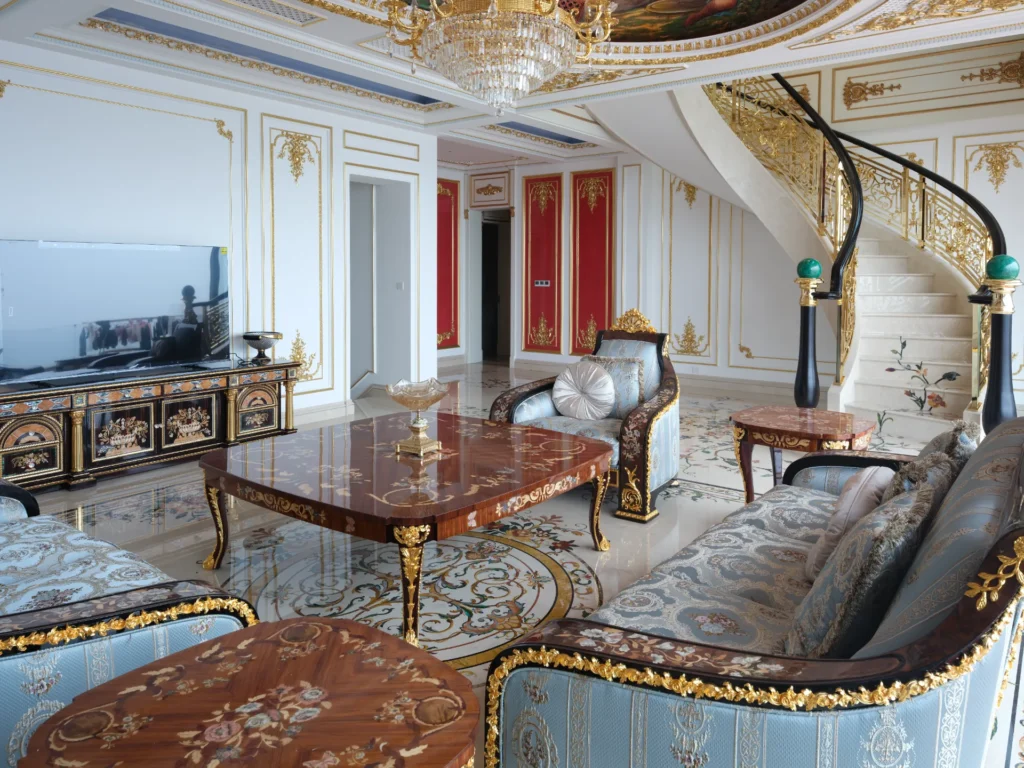Ornate marble inlay floor with floral marquetry in a luxury interior with gilded furniture.