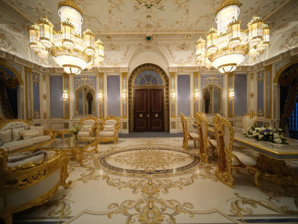 Ornate marble floor inlay with a central waterjet medallion and gold scroll motifs in a luxury interior.