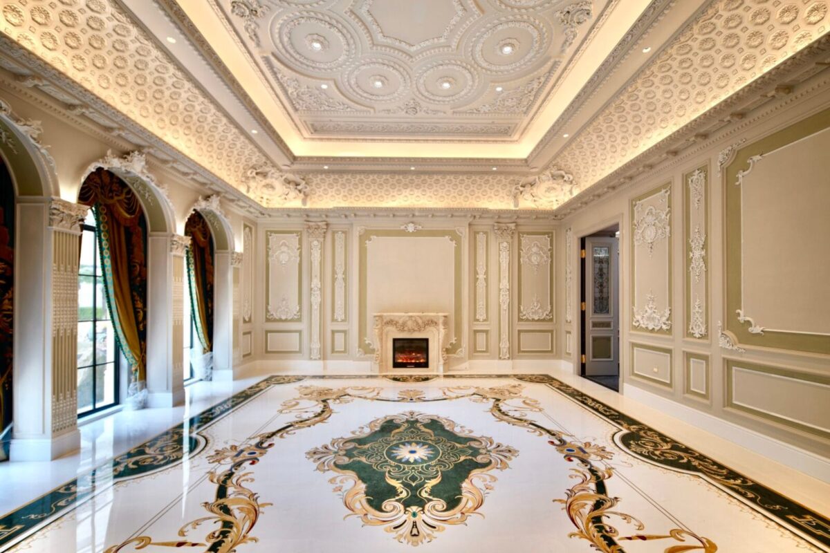 Ornate marble floor inlay with green and gold scrollwork in a luxury interior.